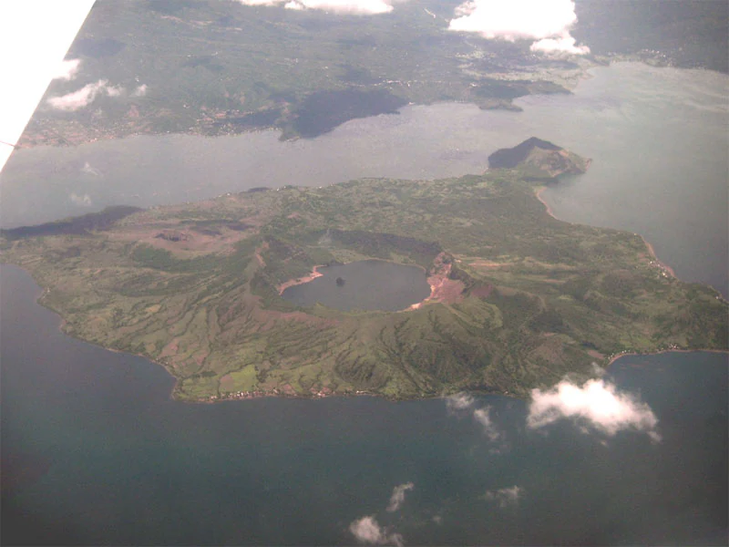 An aerial view of the volcanic island in the middle of Taal Lake, showing the main crater lake.