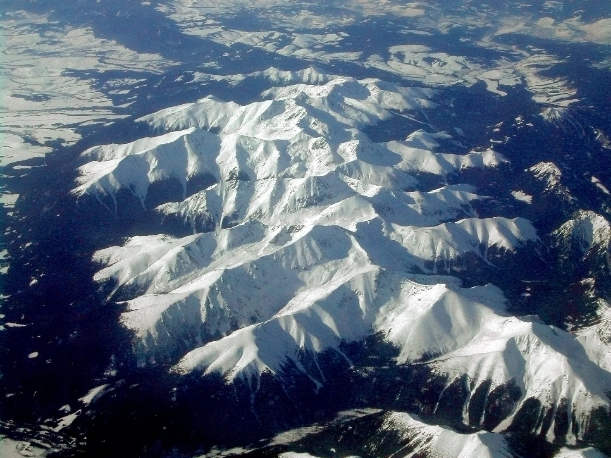 Vista aérea de picos y crestas montañosas nevadas en un paisaje montañoso