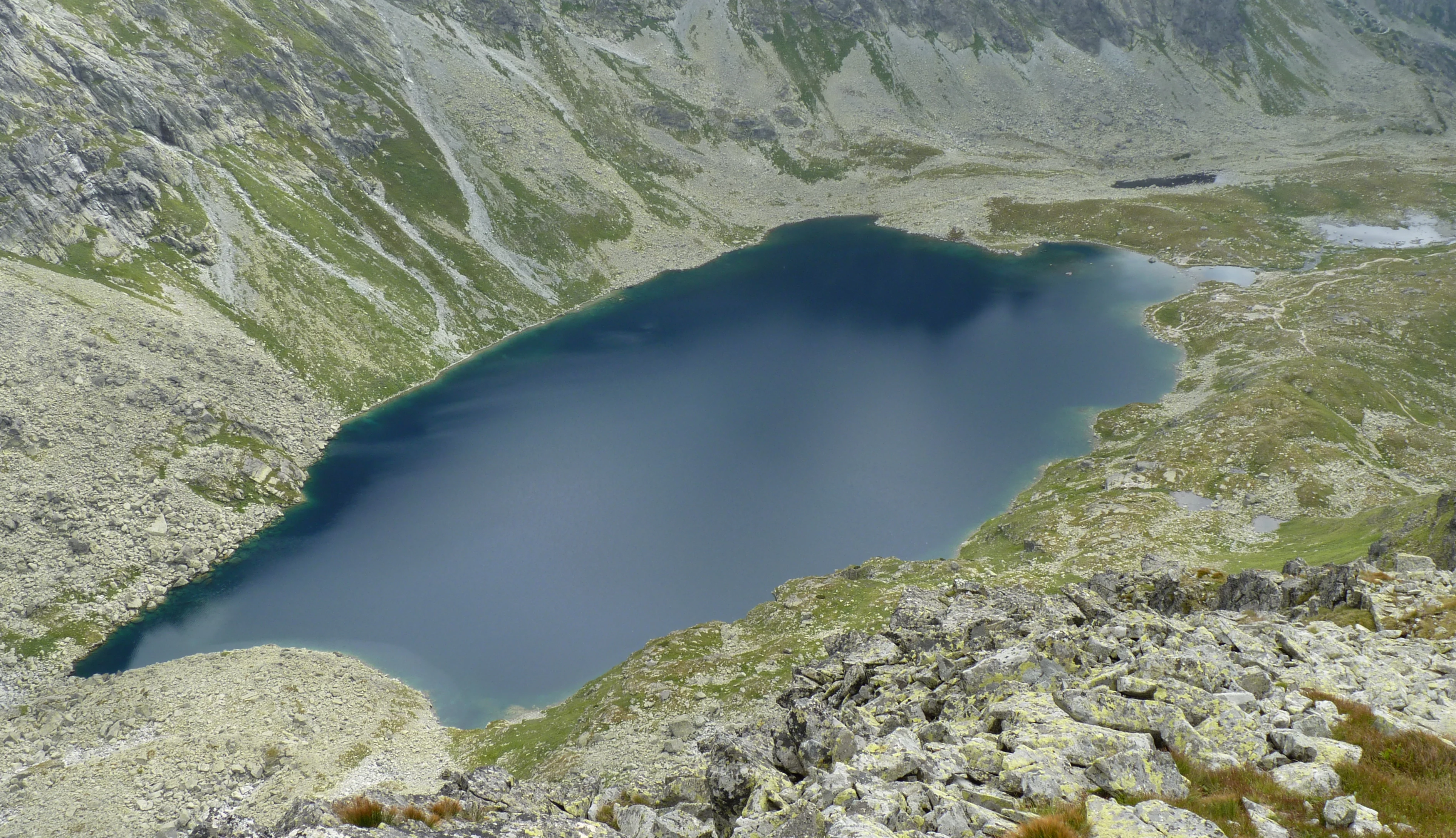 Un lago de gran altitud rodeado de laderas rocosas y vegetación escasa en el Parque Nacional de los Tatras, Eslovaquia