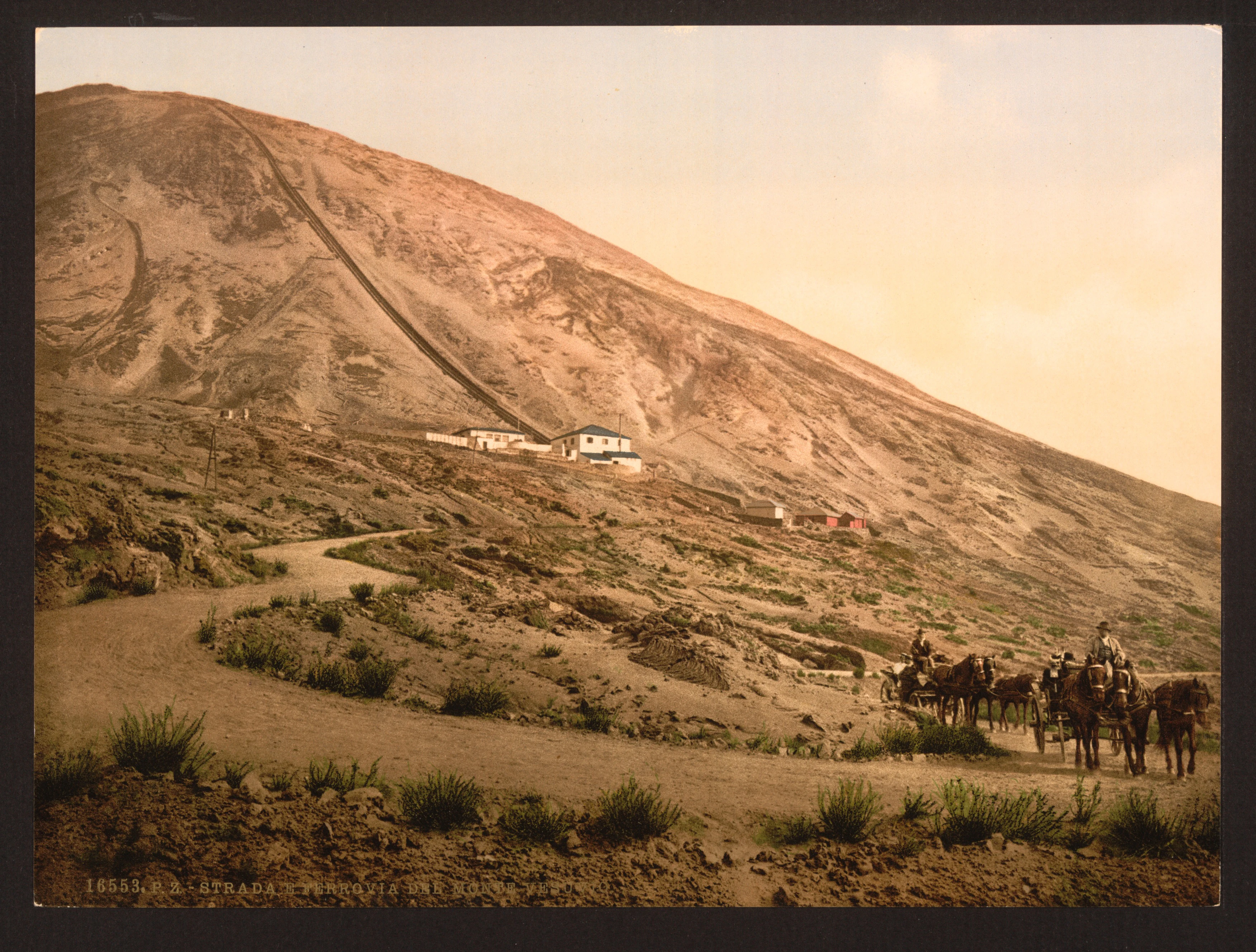 Sepia-toned photograph of Mount Vesuvius showing a winding dirt road, sparse vegetation, and a group of people on horseback in the foreground