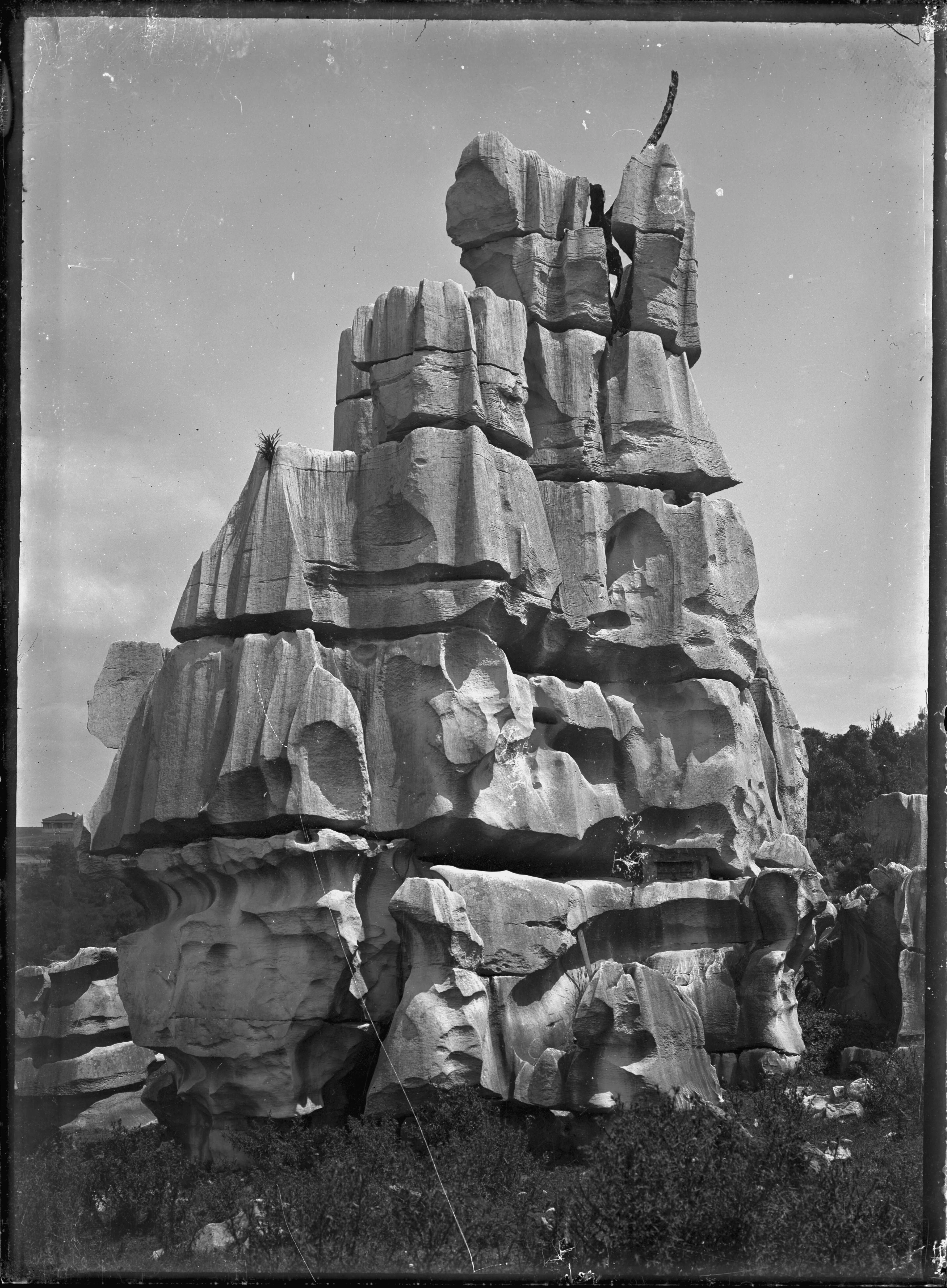 A black and white archival photograph of the tall, jagged, and weathered limestone formation known as Cathedral Rock at Waro.